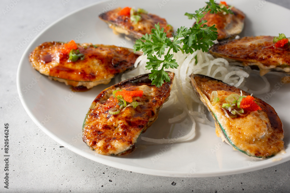 A view of a plate of baked mussels. A view of a plate of baked mussels.