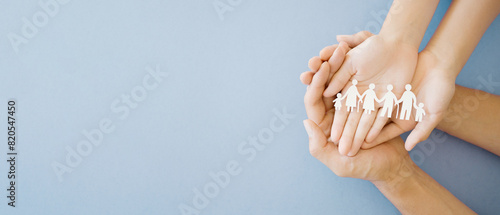 Hands holding multi generation family paper, family wellness, health insurance concept photo