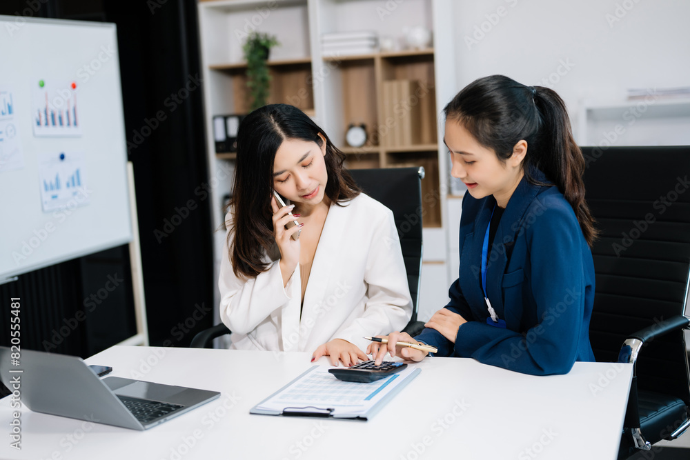 Two business workers talking on the smartphone and using laptop at office. Two business workers talking on the smartphone and using laptop at office.