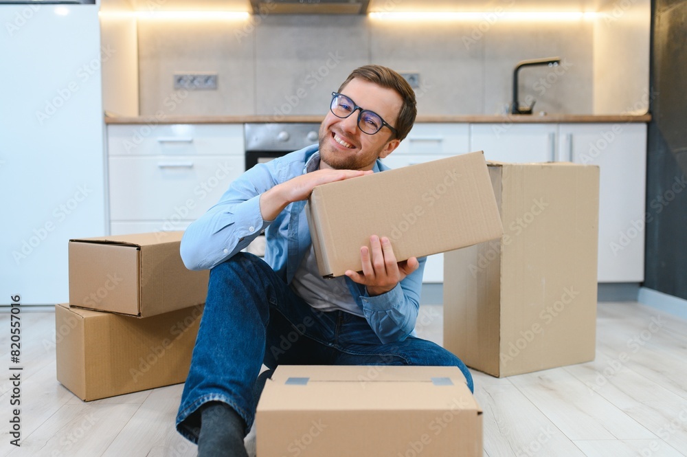 Happy man with cardboard box in new home Happy man with cardboard box in new home