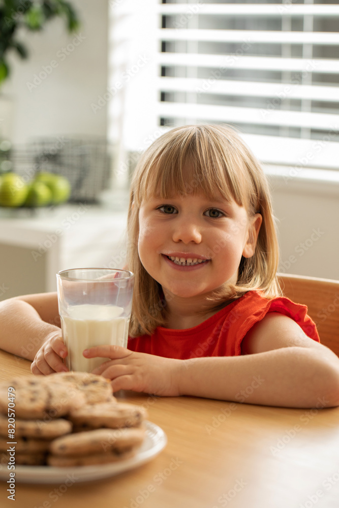 Cheerful girl enjoying fresh milk and homemade cookies, perfect for a wholesome snack time. Cheerful girl enjoying fresh milk and homemade cookies, perfect for a wholesome snack time.