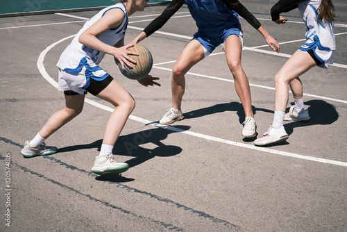 Teenage girls play street basketball on a street court in the city. photo