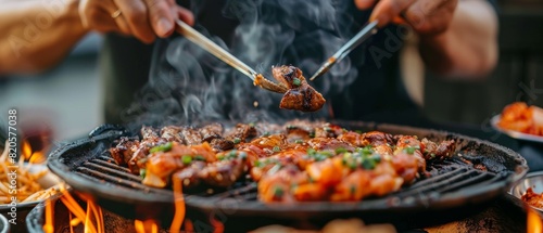 Professional enjoying a bite of Korean BBQ, hands and mouth in focus, showcasing the rich flavors and cultural authenticity photo