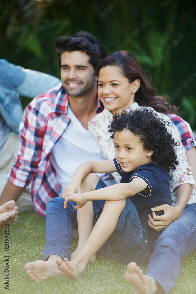 Fototapeta premium Smile, nature and child with parents in park bonding together on outdoor family vacation. Happy, love and boy kid with mother and father relaxing on grass in garden for countryside holiday or trip.