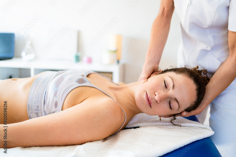 Obraz premium Female osteopath manipulating neck of patient