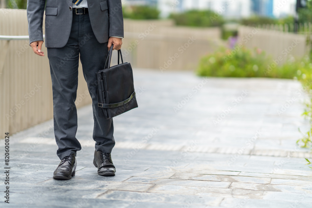 Confidence Asian businessman office worker in suit holding briefcase walking city street at office district in the city. Business people company employee go to work in the morning. Confidence Asian businessman office worker in suit holding briefcase walking city street at office district in the city. Business people company employee go to work in the morning.