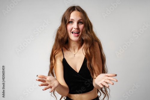 Joyful Young Woman Gesturing With Hands on a Plain Background