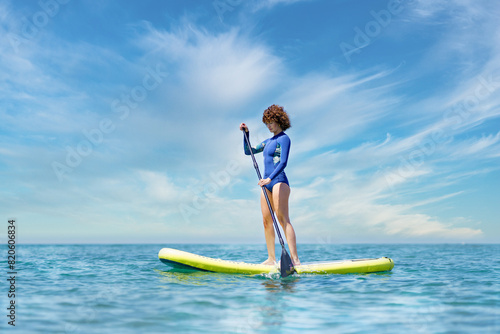 Female pulling paddleboard in seawater