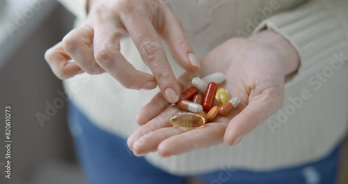 pharmacy and treatment concept - close up view of Caucasian woman holding capsules and tablets in her hand
