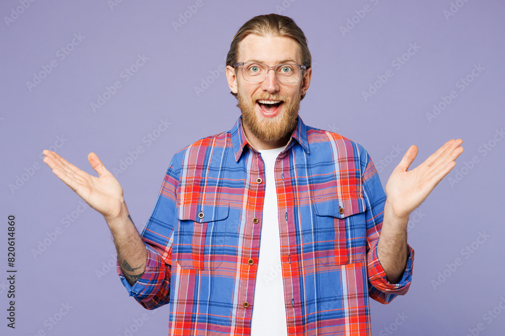 Young surprised shocked excited cool fun happy man he wears blue shirt casual clothes looking camera spread hands isolated on plain pastel light purple background studio portrait. Lifestyle concept. Young surprised shocked excited cool fun happy man he wears blue shirt casual clothes looking camera spread hands isolated on plain pastel light purple background studio portrait. Lifestyle concept.