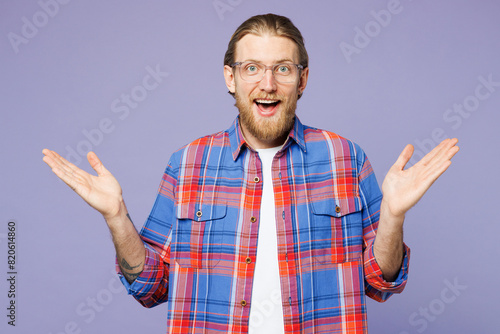 Young surprised shocked excited cool fun happy man he wears blue shirt casual clothes looking camera spread hands isolated on plain pastel light purple background studio portrait. Lifestyle concept.