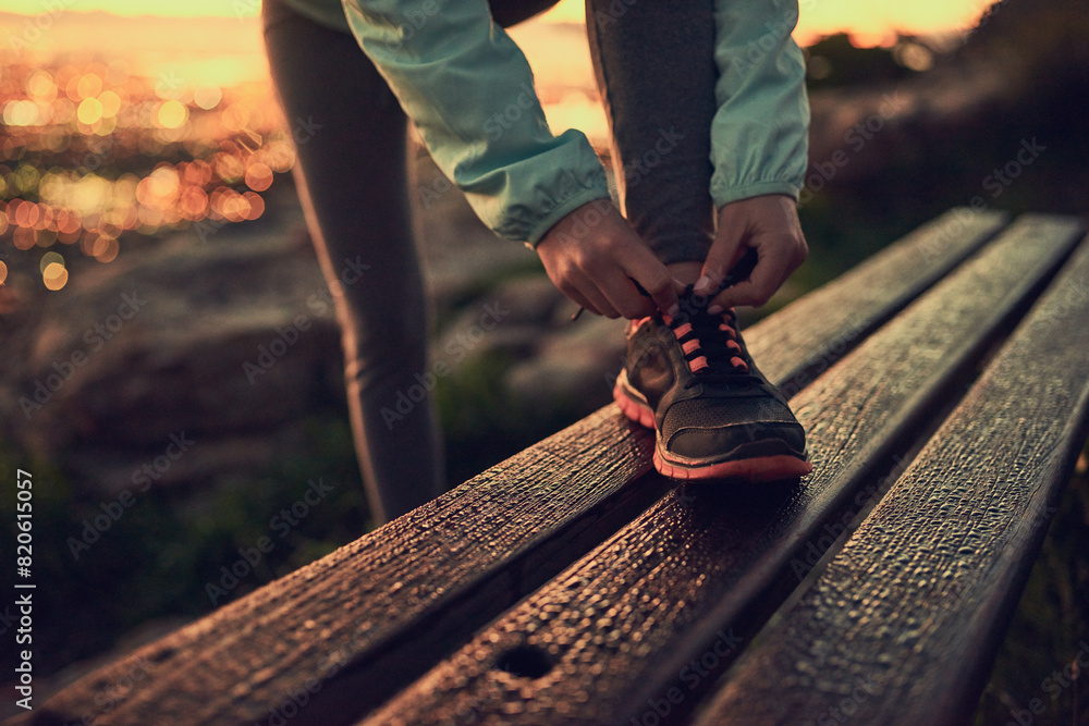 Person, hands and tying shoe with hiker on bench for morning walk or trekking on outdoor mountain. Closeup of human getting ready, preparation or tie laces for hiking, journey or exercise in nature