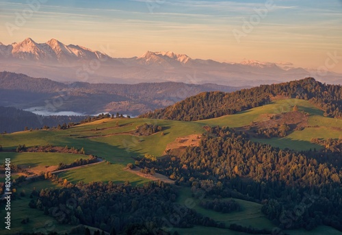 Mountain scenery with green pastures and rocky mountains in the background during the day. Grass fields Pieniny mountains in autumn, Slovakia. View towards east from Lesnicke sedlo photo