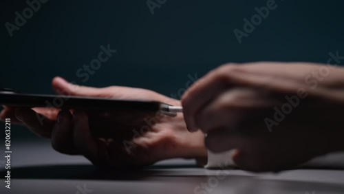 Female hand charging charge mobile phone on black table. Young woman holding smartphone in hand and connecting plug in charger type-c cable. EU law to force USB-C chargers. Shooting in slow motion. photo