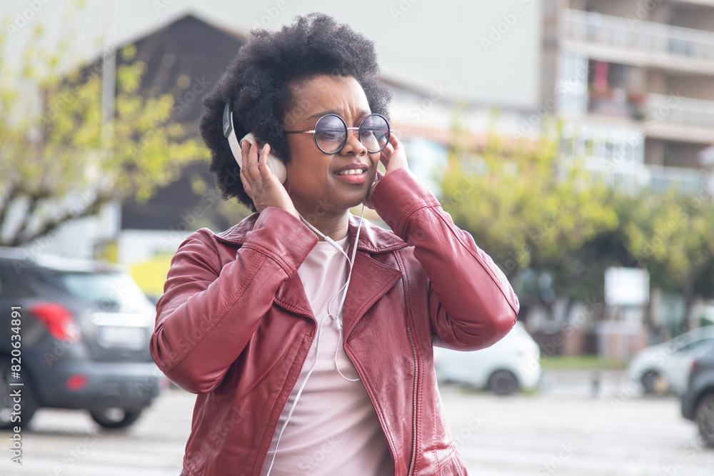young woman with headphones walking on the street young woman with headphones walking on the street