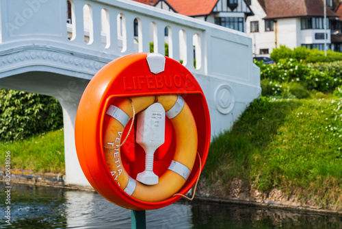 Billede på lærred Red Lifebuoy or life saver on a waterway