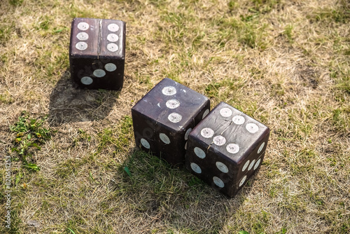 Three dice big size on the ground whitout people