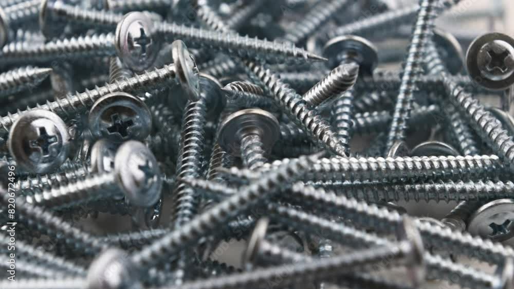 Self-tapping screws with press washer. Movement with rotation. Close-up, side view, small depth of field. 4,2mm x 50mm. Self-tapping screws with press washer. Movement with rotation. Close-up, side view, small depth of field. 4,2mm x 50mm.