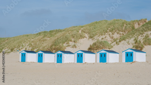 A colorful row of beach huts standing proudly on a sandy beach in Texel, Netherlands, basking in the suns glow. De Koog beach Texel © Fokke Baarssen