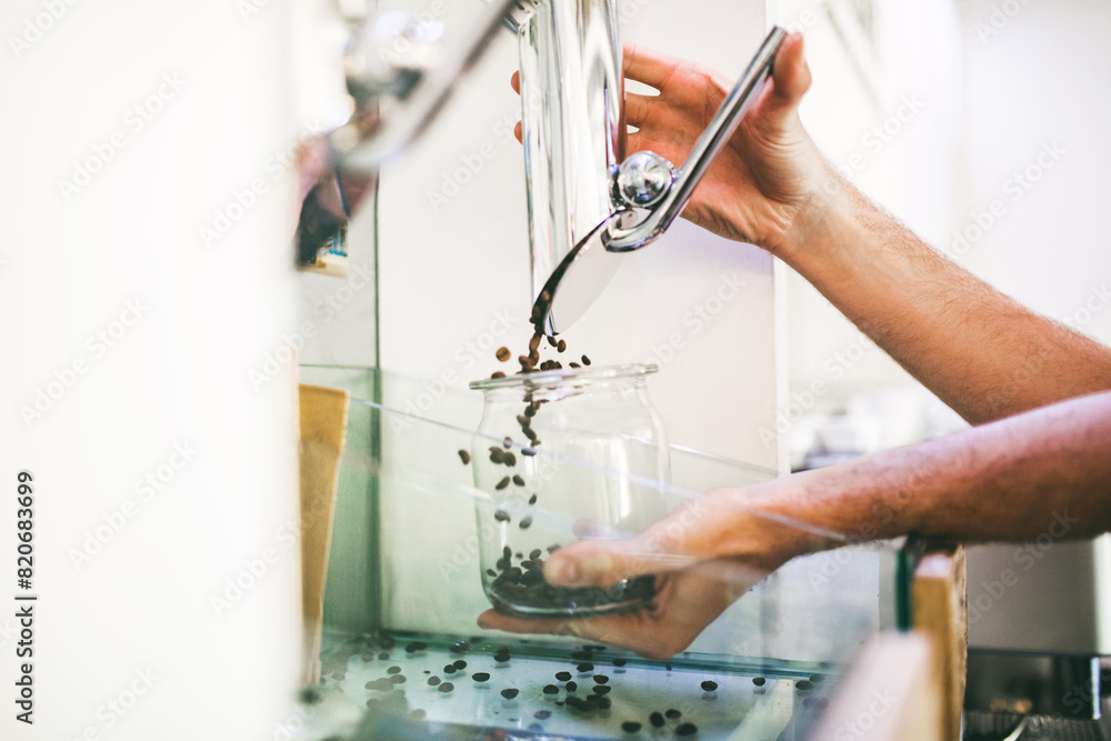 Barista working in coffee shop, pouring coffee beans from coffee hopper. Barista working in coffee shop, pouring coffee beans from coffee hopper.