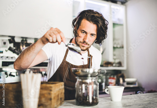Fotografie Handsome barista working in coffee shop, preparing coffee