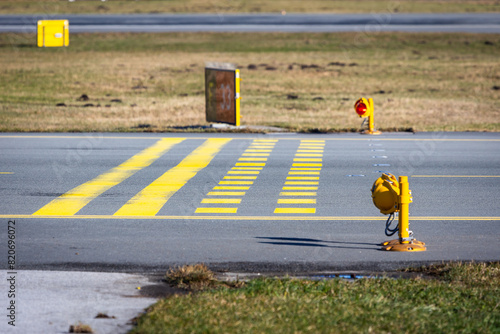 Runway holding point with stop bars and red lights. Airport safety infrastructure.