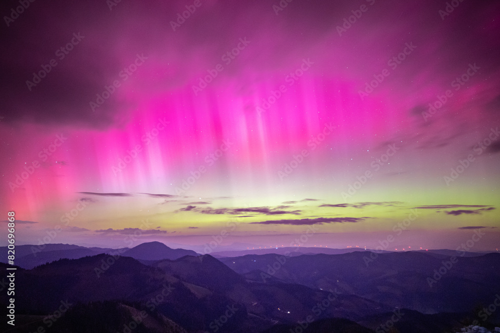 Colorful green and pink northern lights over the alps of central europe, Austria. Aurora borealis event on May 10, 2024 due to massive solar storm and sun eruption.