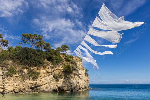 Fototapeta Naklejka Na Ścianę i Meble -  White sheets waving in the wind above the beach on Cameo Island, Zakynthos, Greece
