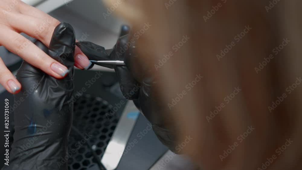 Close-up Unrecognizable Woman Manicurist Serves a Client in a Spa Beauty Salon. Feminine Body and Nail Care. Concept of Working in the Service Sector. Close-up Unrecognizable Woman Manicurist Serves a Client in a Spa Beauty Salon. Feminine Body and Nail Care. Concept of Working in the Service Sector.