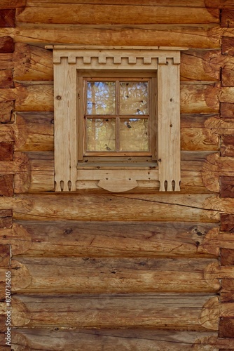 Closeup od decorative framed window on a log building.