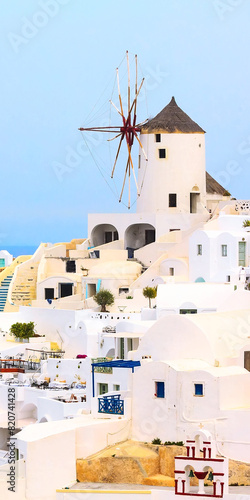 Santorini island, Greece, Oia village windmill close-up and white houses, vertical banner © Nataliya