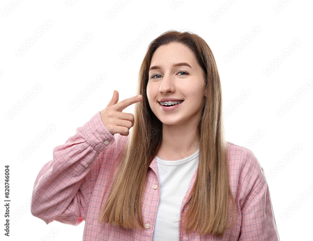 Portrait of smiling woman pointing at her dental braces on white background Portrait of smiling woman pointing at her dental braces on white background