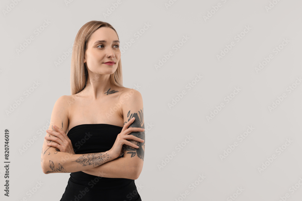 Beautiful tattooed woman on light background, space for text Beautiful tattooed woman on light background, space for text