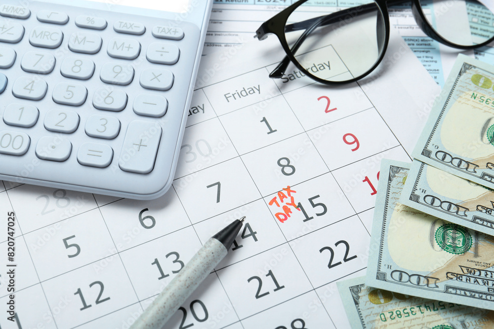 Calendar with date reminder about tax day, documents, money, pen, calculator and glasses, closeup Calendar with date reminder about tax day, documents, money, pen, calculator and glasses, closeup