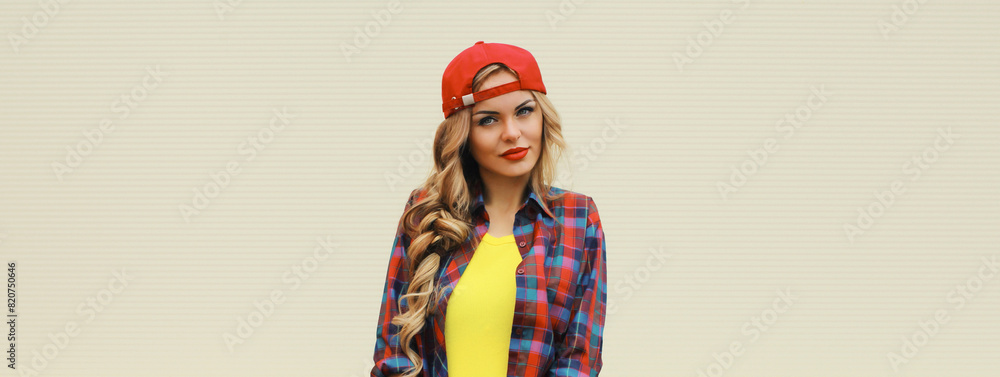 Portrait of stylish young blonde woman in red baseball cap posing on white wall background Portrait of stylish young blonde woman in red baseball cap posing on white wall background