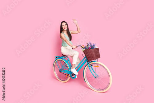 Photo of cute cheerful lovely woman wear stylish clothes walk bicycle meeting isolated on pink color background © deagreez