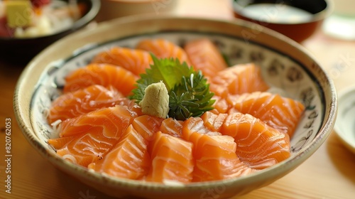 Sashimi salmon with wasabi sauce on a white plate at a Japanese restaurant.