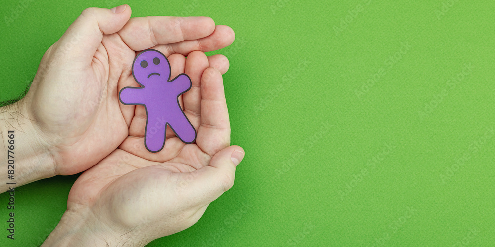 World mental health day. Male hands holding paper men figures with different emotions World mental health day. Male hands holding paper men figures with different emotions