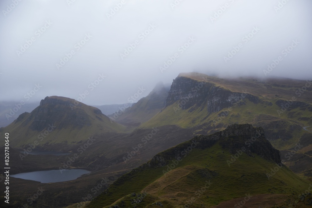 Fototapeta premium Stunning landscape of a picturesque lake and steep mountains on a foggy day