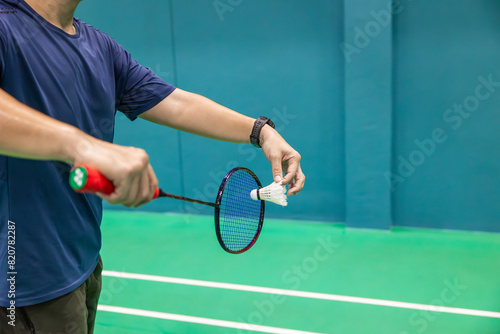 Badminton player hand serving holding shuttlecock and professional badminton racket at indoor sport badminton court © Quality Stock Arts