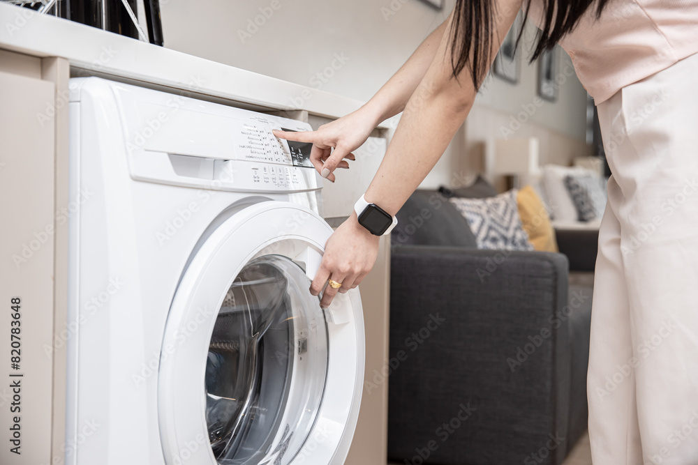 closeup people home house maid using front load washing machine touch press program button closeup people home house maid using front load washing machine touch press program button