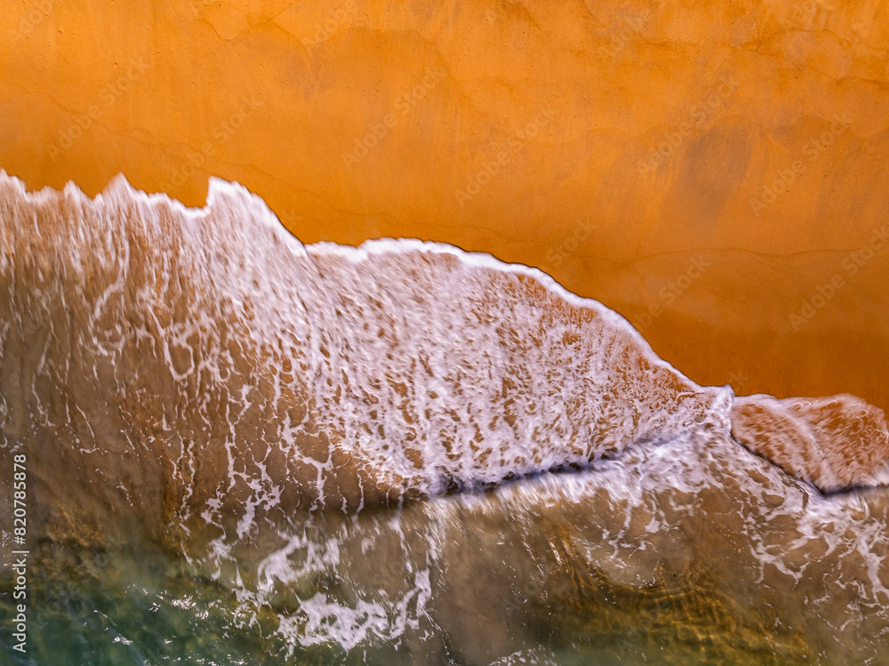 Obraz premium Amazing Top view dark sea beach landscape background,Summer sea waves crashing on sandy shore seascape background,High angle view ocean nature background
