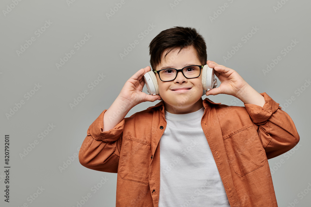 little boy with boy with Down syndrome with glasses listening to music. little boy with boy with Down syndrome with glasses listening to music.