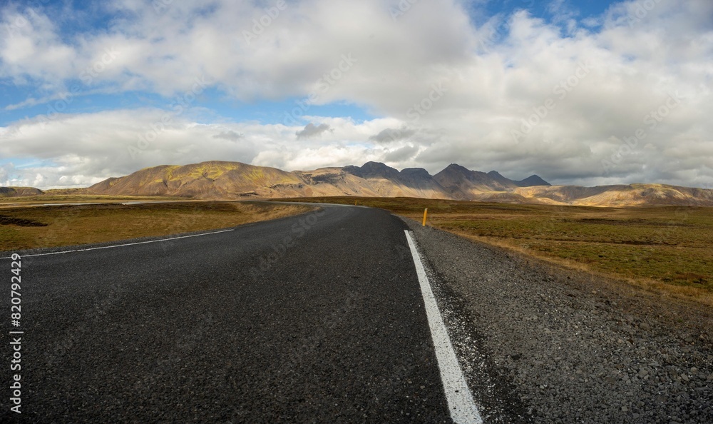 Fototapeta premium View of an empty stretch of highway winding through a spectacular mountain range in Iceland