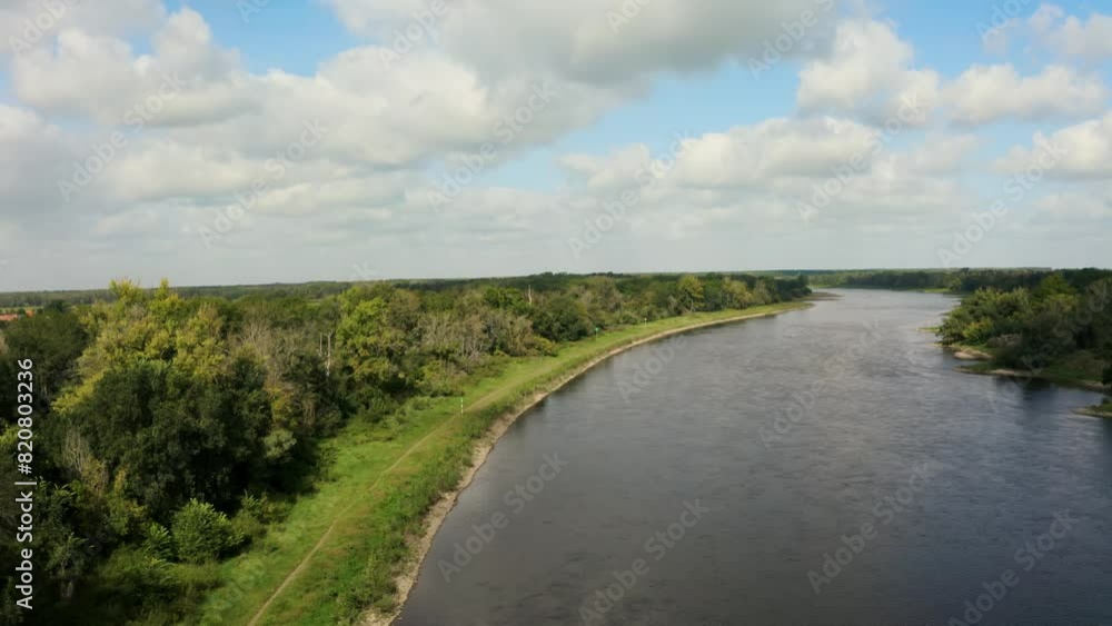 Drone view of a river between green rural fields on a cloudy day Drone view of a river between green rural fields on a cloudy day