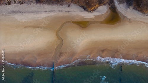Drone perspective: Deserted shoreline, golden hour glow. © Grzegorz