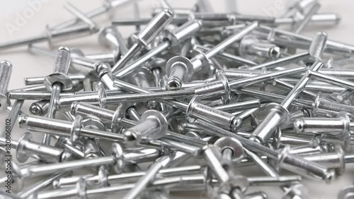 Aluminum rivets. Movement with rotation. Close-up, side view, small depth of field. photo