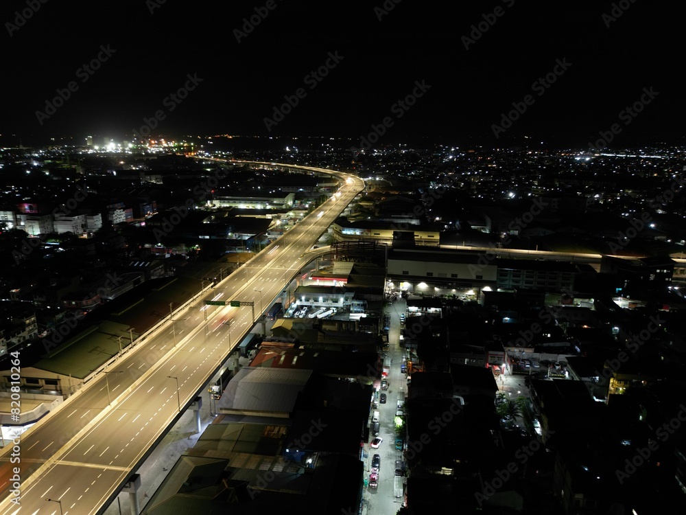 Fototapeta premium long freeway at night with cars moving on it near the city