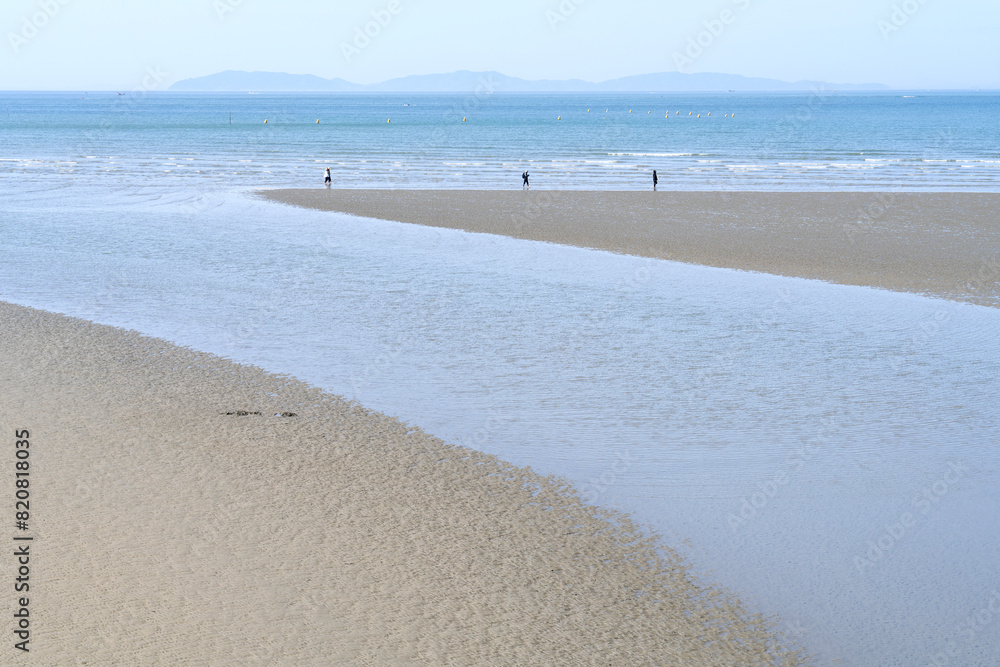 Obraz premium View of the seaside with the tourists on the beach