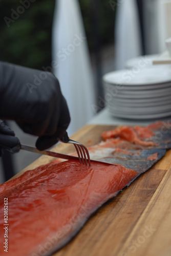 Close-up of waiter slicing salmon
